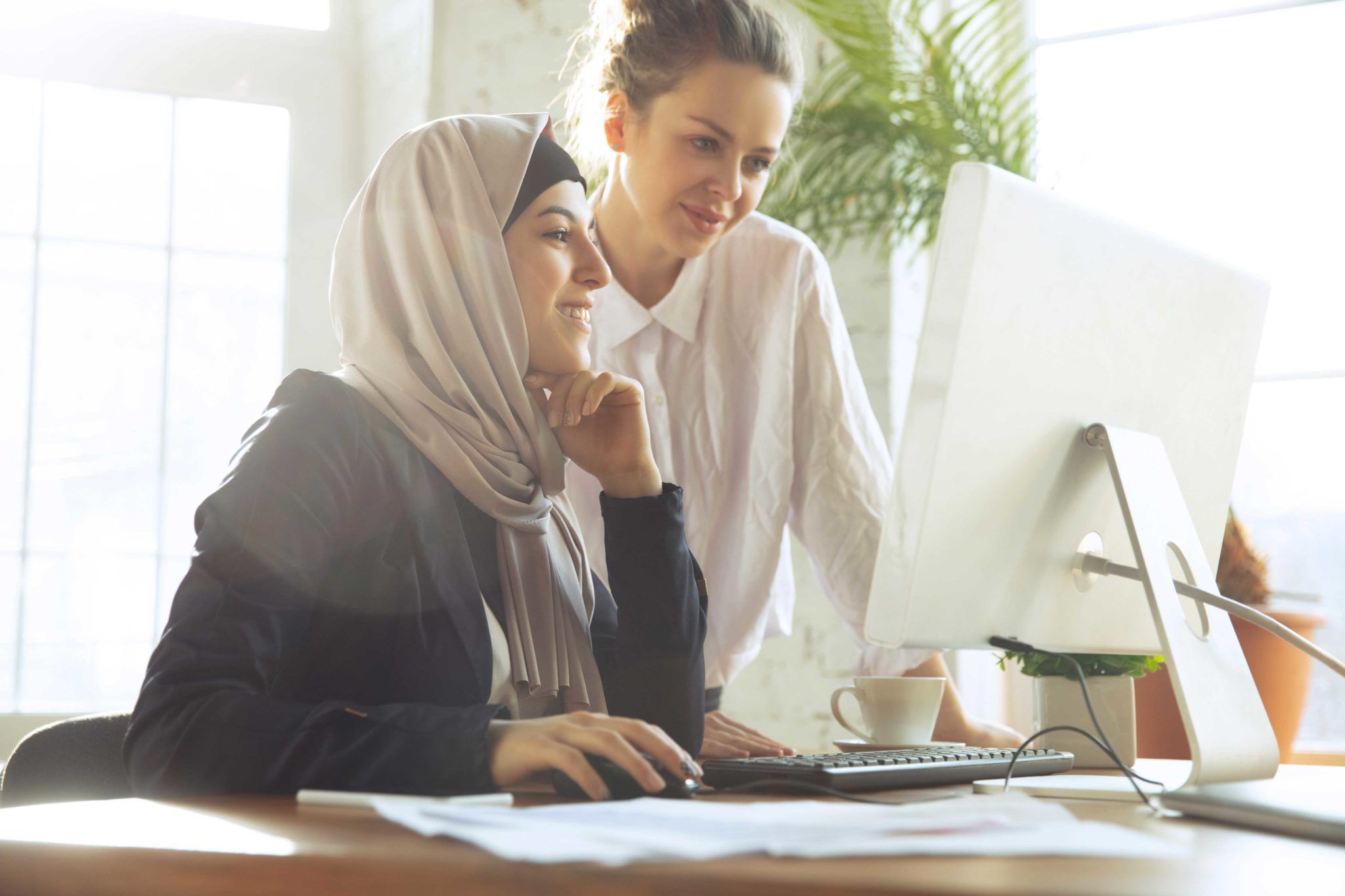 Two women smiling at a computer